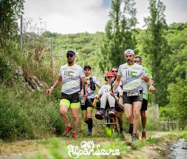 Athletes pushing an adaptive racing wheelchair during an inclusive trail running event in nature.