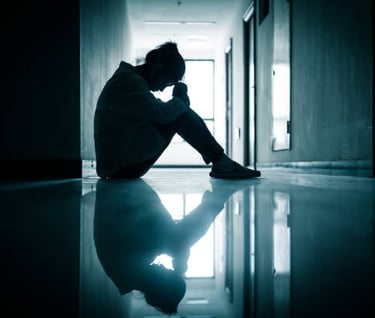 a woman sitting in the dark with anxiety