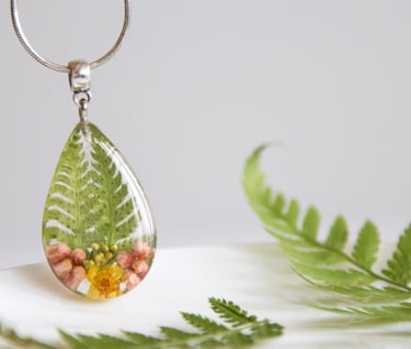 a necklace with a green leafy tear shaped pendant