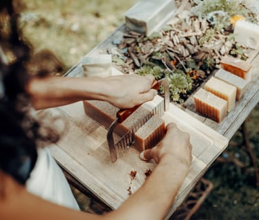 a woman is cutting a block of soap with a knife