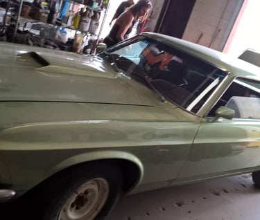 a man in a green shirt is standing next to a car