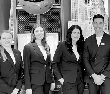 a group of business people standing in front of a building corporate hospitality events team