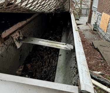 gutter filled with soggy debris due to failed gutter guard system