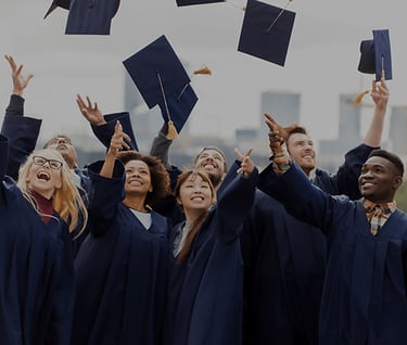 a group of people in graduation gowns throwing their caps