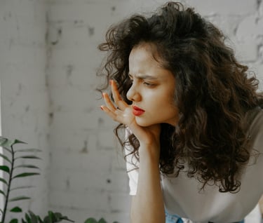 Woman with hand on chin, looking confused