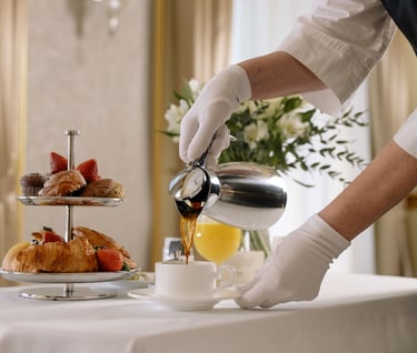 Gloved server pouring tea for a guest