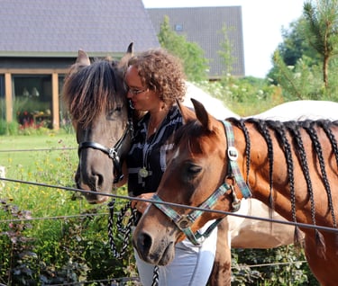 Claudia met twee paarden een bruine en een bruin wit paard
