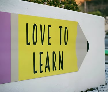 Colorful sign with a stylized pencil shape and 'LOVE TO LEARN', reflecting Admit 360