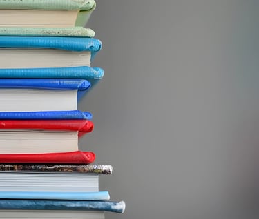 Stack of colorful books representing study abroad scholarship and assistantship guidance