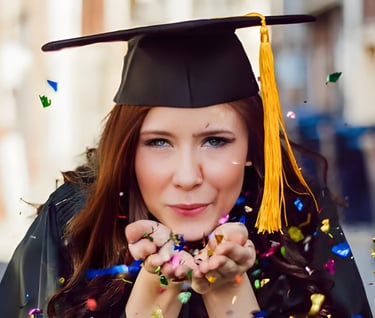 Smiling graduate in cap and gown with confetti, symbolizing successful scholarship guidance Admit360