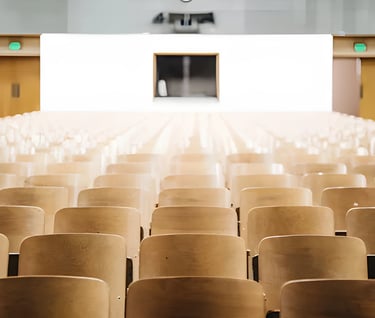 Wooden chairs facing a stage indicating a formal event, reflecting Admit 360's strategic guidance