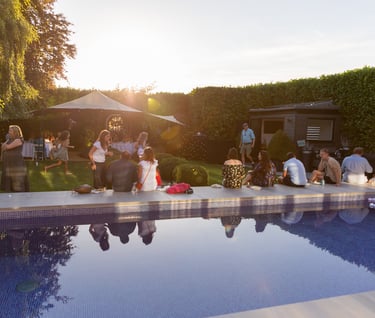 a group of people standing around a pool