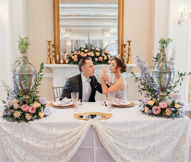 a man and woman sitting at a table with flowers