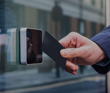User tapping a proximity access card on a card reader at a secured building entrance