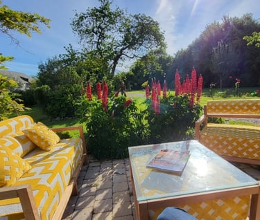 Terrasse ensoleillée avec un salon de jardin aux tissus à motifs texturé