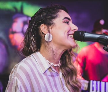 woman singing into microphone on stage