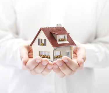Protection of the home, hands hold a house, as a symbol of protection