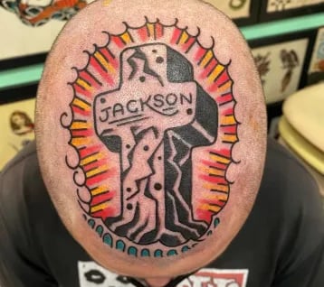 a man with a tattoo on his head of a cross with the name Jackson on it