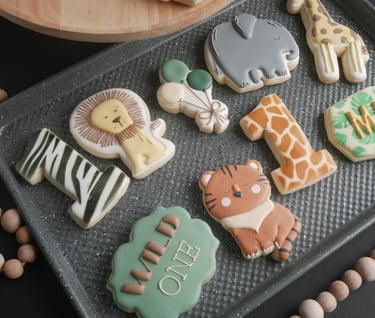 a tray of cookies with a variety of zoo animals