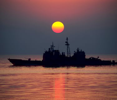 a boat in the water with a sunset in the background