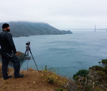a man standing on a hill overlooking a bridge