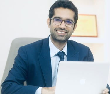a man in a suit and tie is smiling and holding a laptop