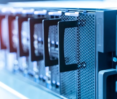 Close-up of server rack hardware with drive bays in a high-tech data center room.
