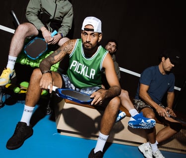 Professional pickleball players posing on a court with Picklr jerseys and paddles.