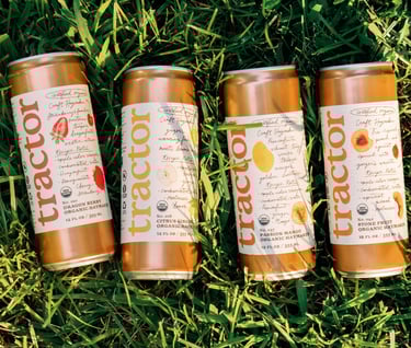 three cans of iced tea on the grass