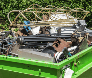 a green steel bin filled with metal scrap 