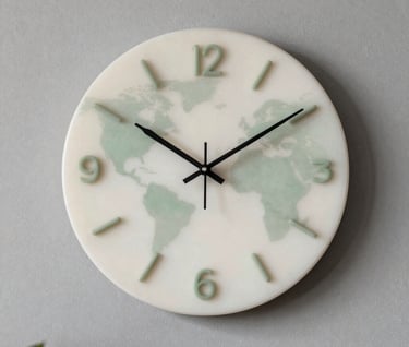 A elegant Almond White and Sage Green resin wall clock hanging on a minimal Pebble Grey wall in a International / Global home interior.