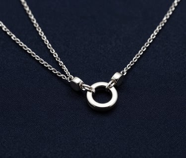 A sharp, high-fashion macro photograph of sleek, modern silver accessories worn by a performer, set against a dark navy fabric texture. The composition is artistic and minimalist, reflecting a sophisticated US creative vision.