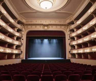 A wide-angle shot of a majestic European opera house interior. The plush seats are deep burgundy (#6B242D) and the architecture features soft sand (#DDCBC0) and light grey (#F2F0EB) details. The stage is bathed in a dramatic spotlight.