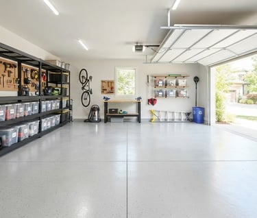 Organized garage workshop with black metal shelving, wall-mounted tool racks, and epoxy flooring.