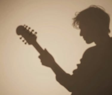 Abstract shadows of a musician playing against a soft almond wall, minimalist and artistic composition, warm inviting atmosphere.