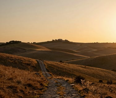 A cinematic landscape of rolling hills in the Spanish countryside during golden hour, with a small stone path leading into the distance. Low-detail areas for a calm mood, warm light, and a soft sand-colored sky.