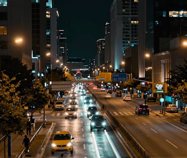 A long-exposure photograph of a cityscape at night, where the moving lights of traffic are blurred into smooth, flowing rivers of slate teal and burnished gold against a dark background. Very sharp detail in the static structures.