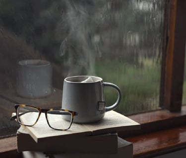 a cup of coffee and a book on a stack of books
