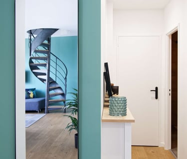 a mirror reflecting a spiral staircase in a hallway