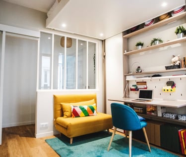 a yellow couch in a room with a blue rug