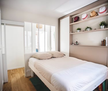 a bed with a white bed and a red suitcase