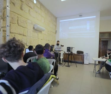 a group of people sitting at tables in a room attending a workshop on music production in lebanon