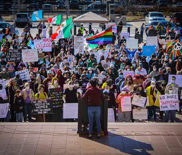 a woman standing in front of a crowd of people holding signs 