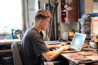 a man sitting at a desk with a laptop computer