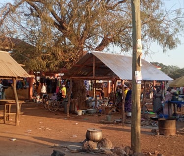 a group of people standing around a tenta, rural market and station market and a station