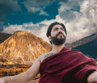 a man sitting on a bed with a mountain in the background
