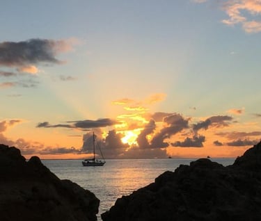 sunset with rays of light and yacht in the sea