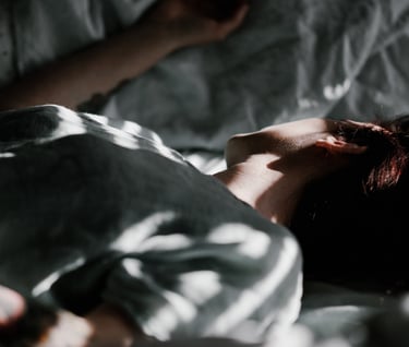 moteris guli lovoje, pasidėjusi galvą ant pagalvės