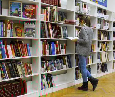 must read books on longevity - a woman is standing in front of a bookcase