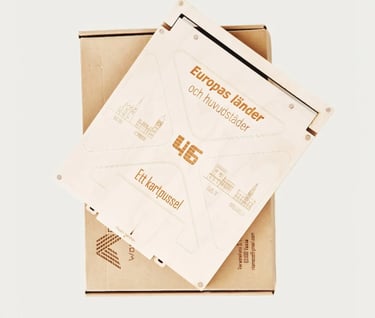 A wooden laser-cut map puzzle of Europe featuring countries and capitals on a cardboard shipping box.